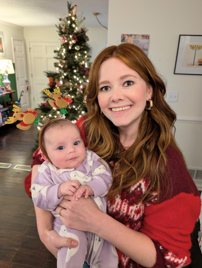 mother with baby daughter in festive christmas wear.
